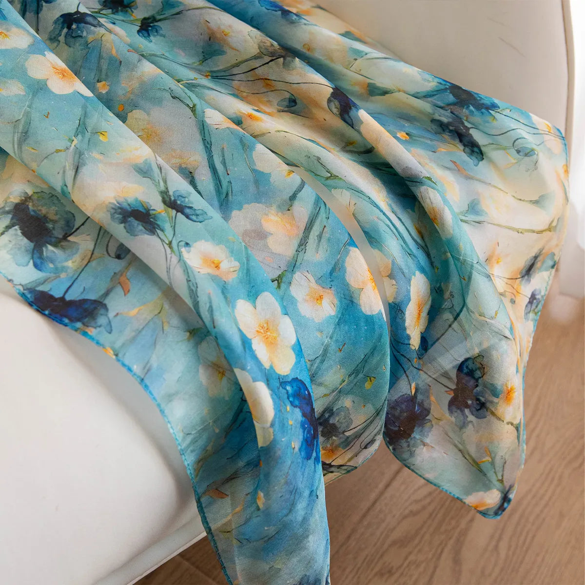 Aqua daisy silk scarf draped on chair