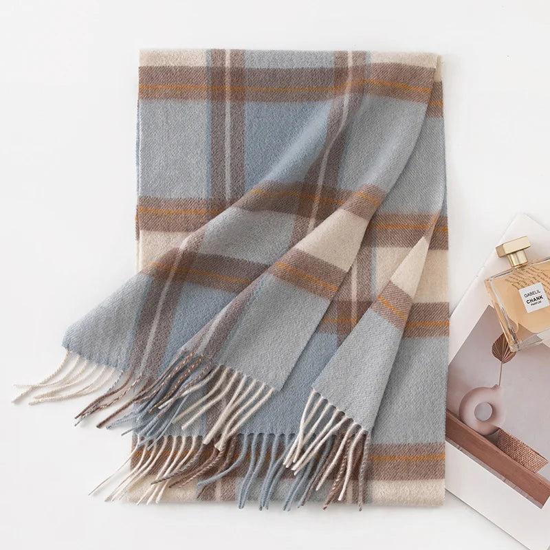 Blue camel cream plaid cashmere scarf folded beside perfume bottle
