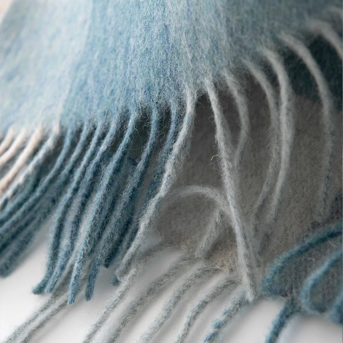 Blue cream twisted fringe beneath a brushed checked edge