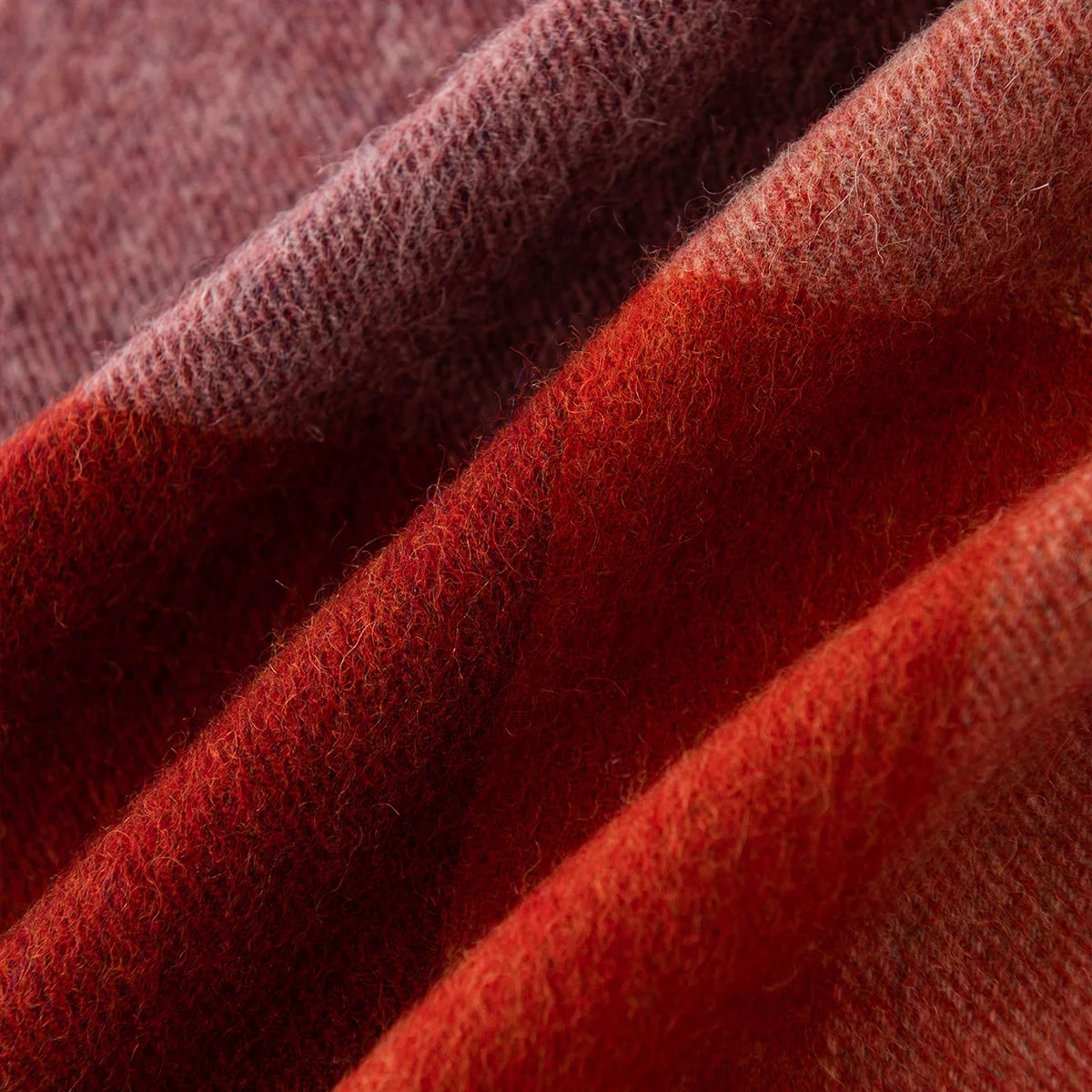 Broad burgundy and rust bands crossing diagonal fabric folds