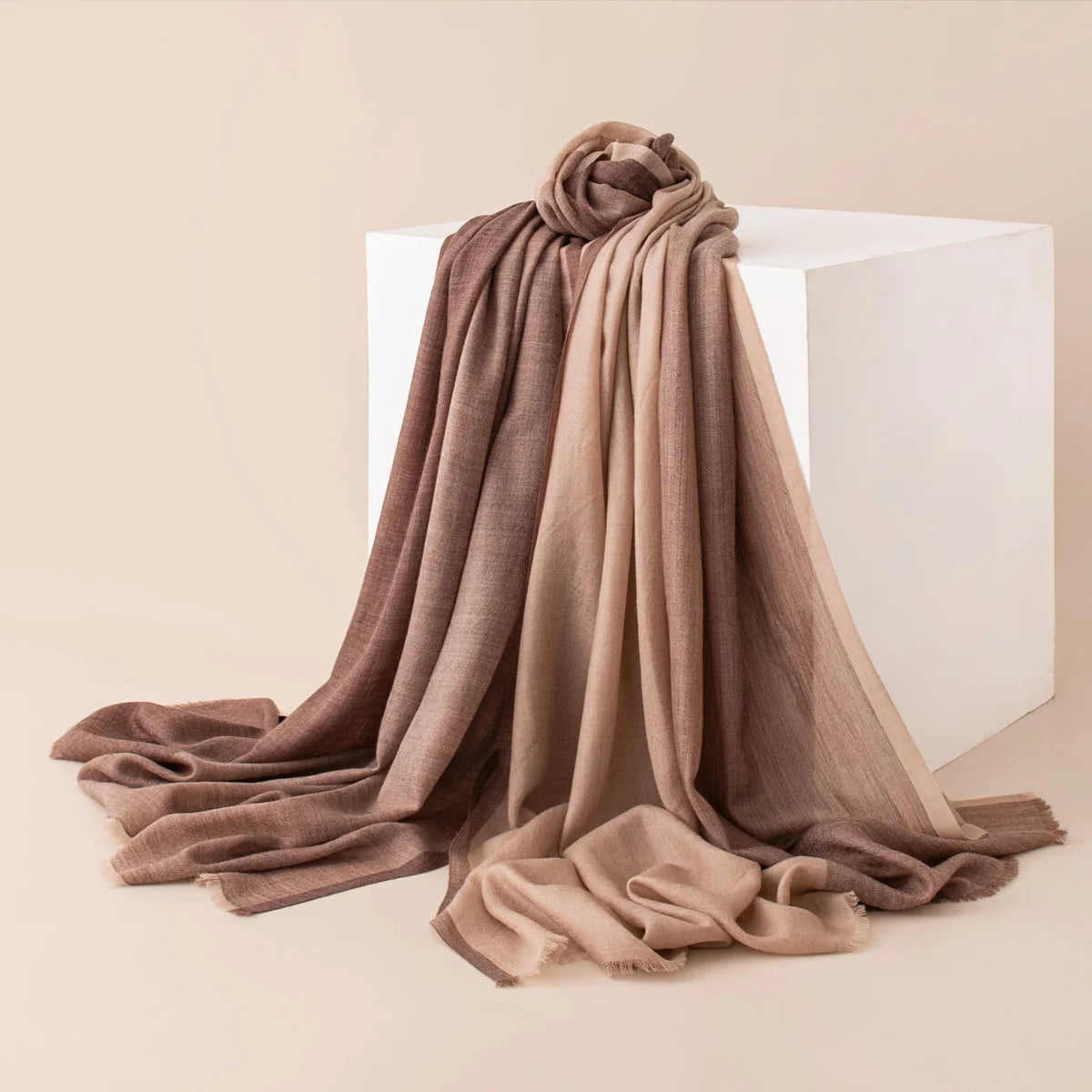 Brown tonal paneled wool scarf gathered beside a white block
