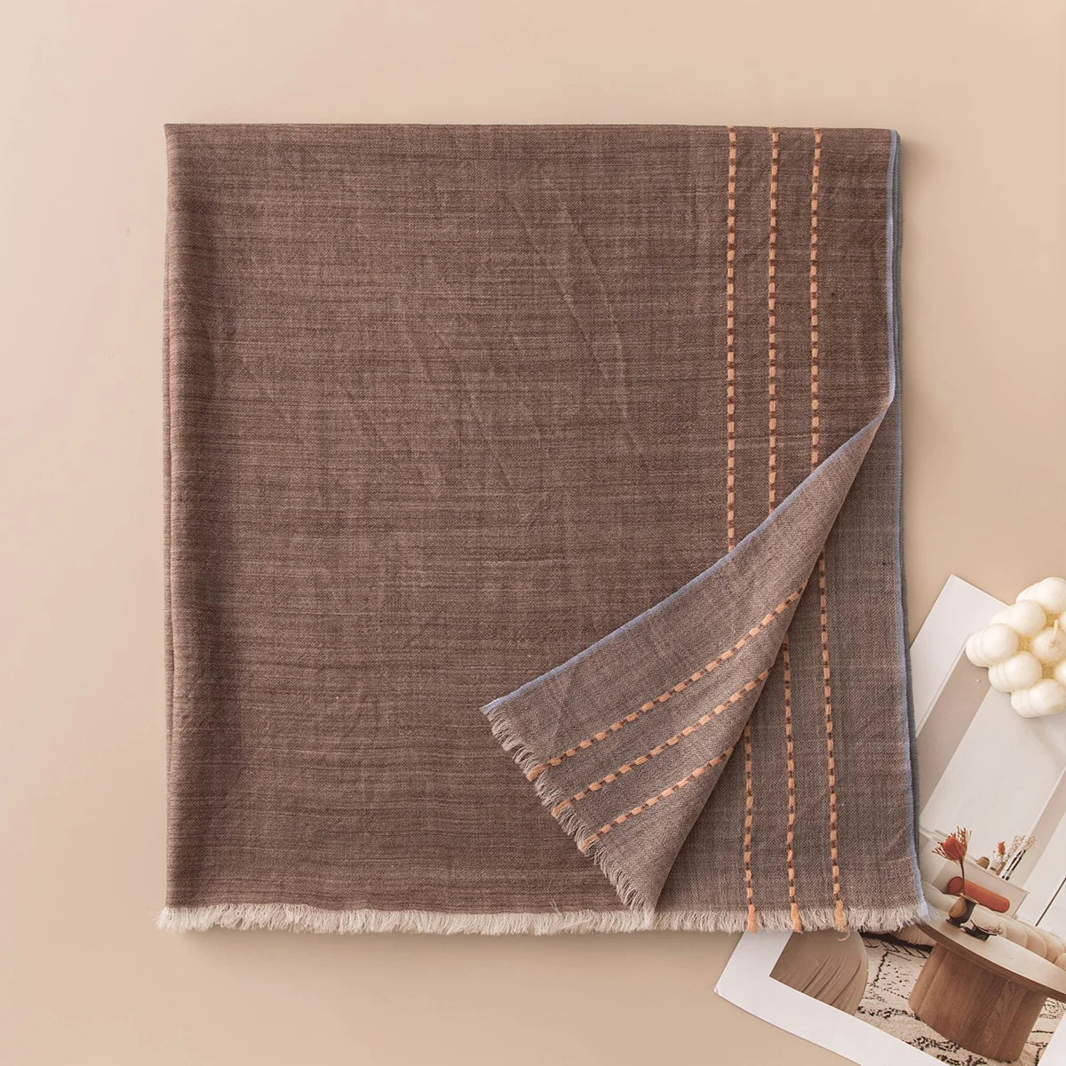 Brown wool scarf with peach stitches and contrasting bound edge