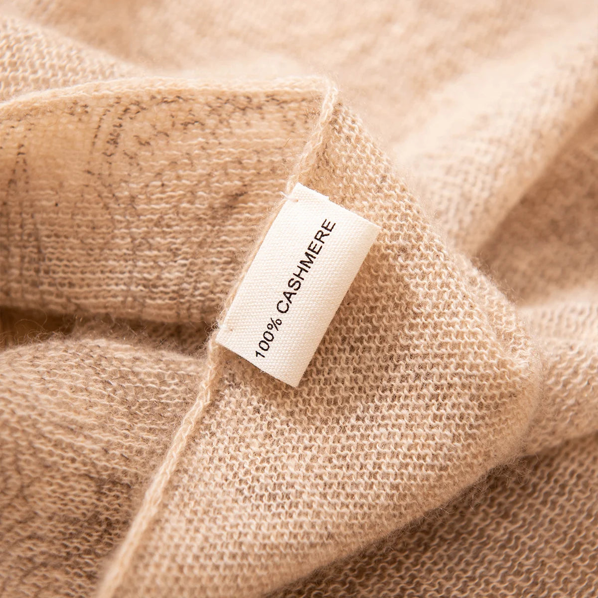Cashmere label attached to loosely woven camel cashmere scarf edge
