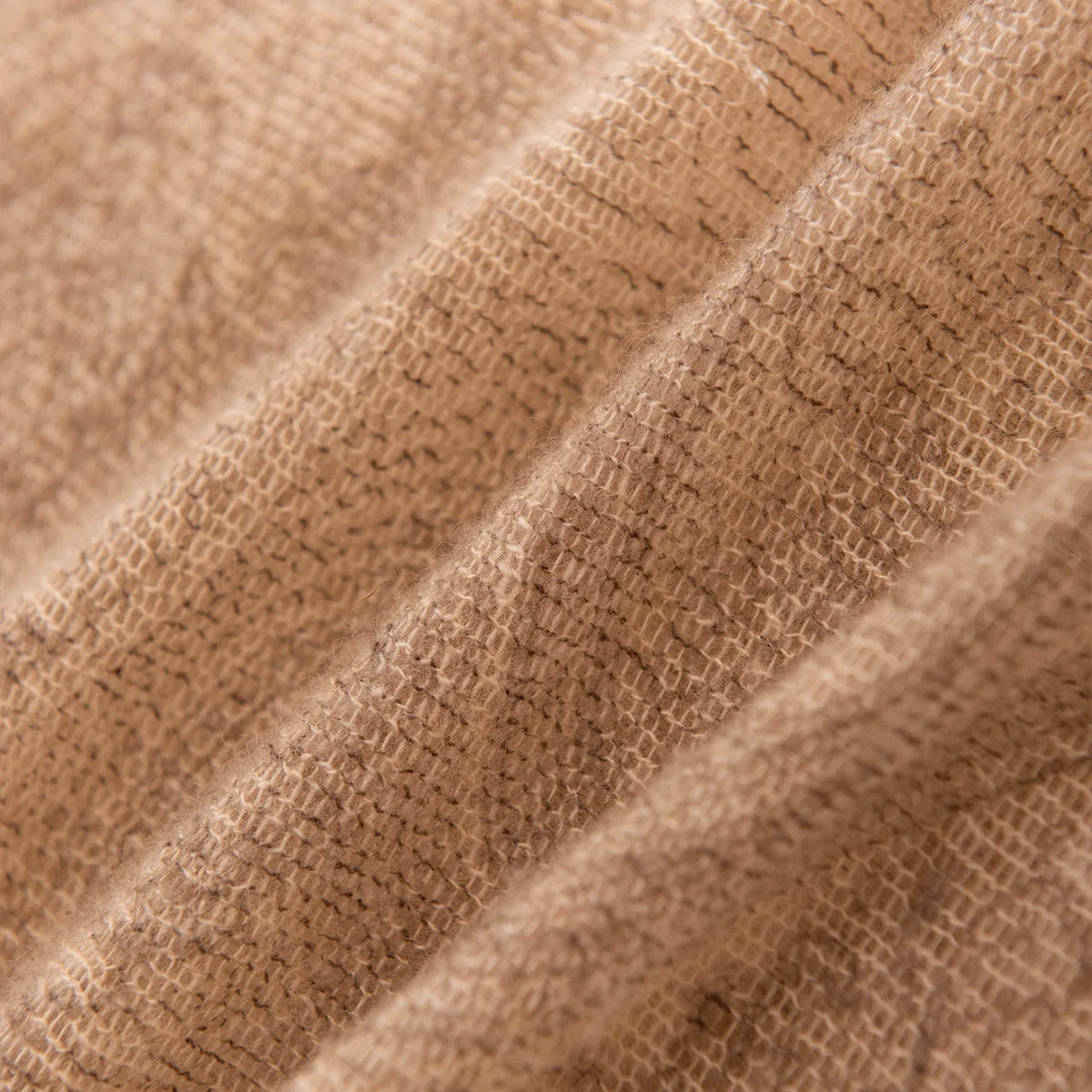 Close view of open woven texture across camel folds