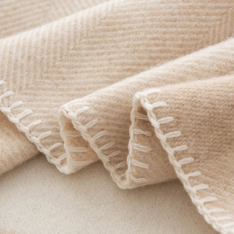 Cream blanket stitching along a beige woven scarf edge