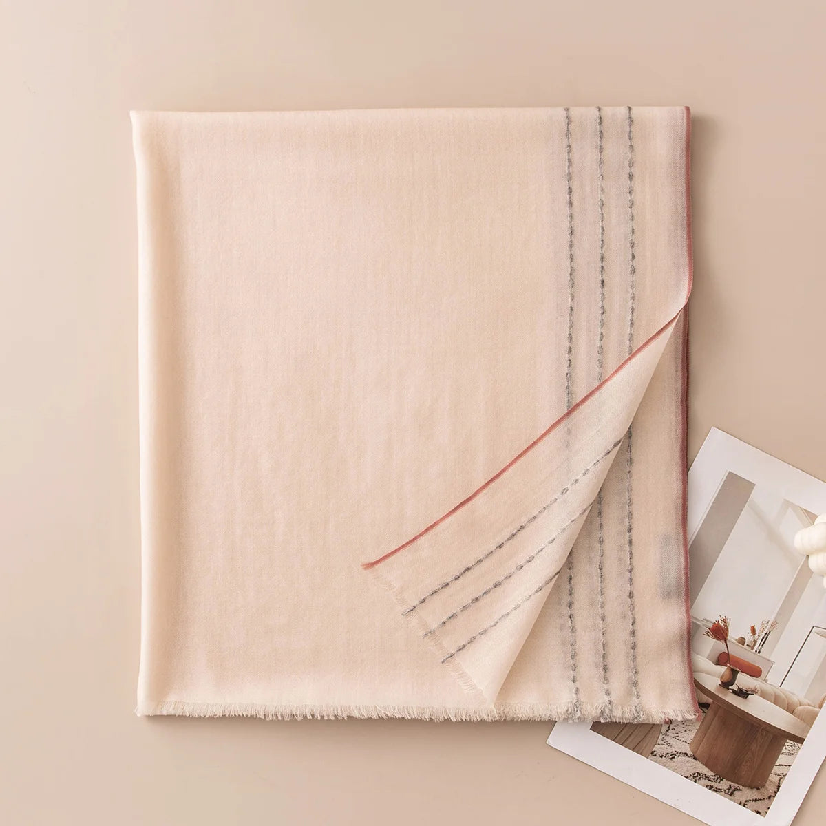 Cream wool scarf displaying fine contrasting stitches along one side