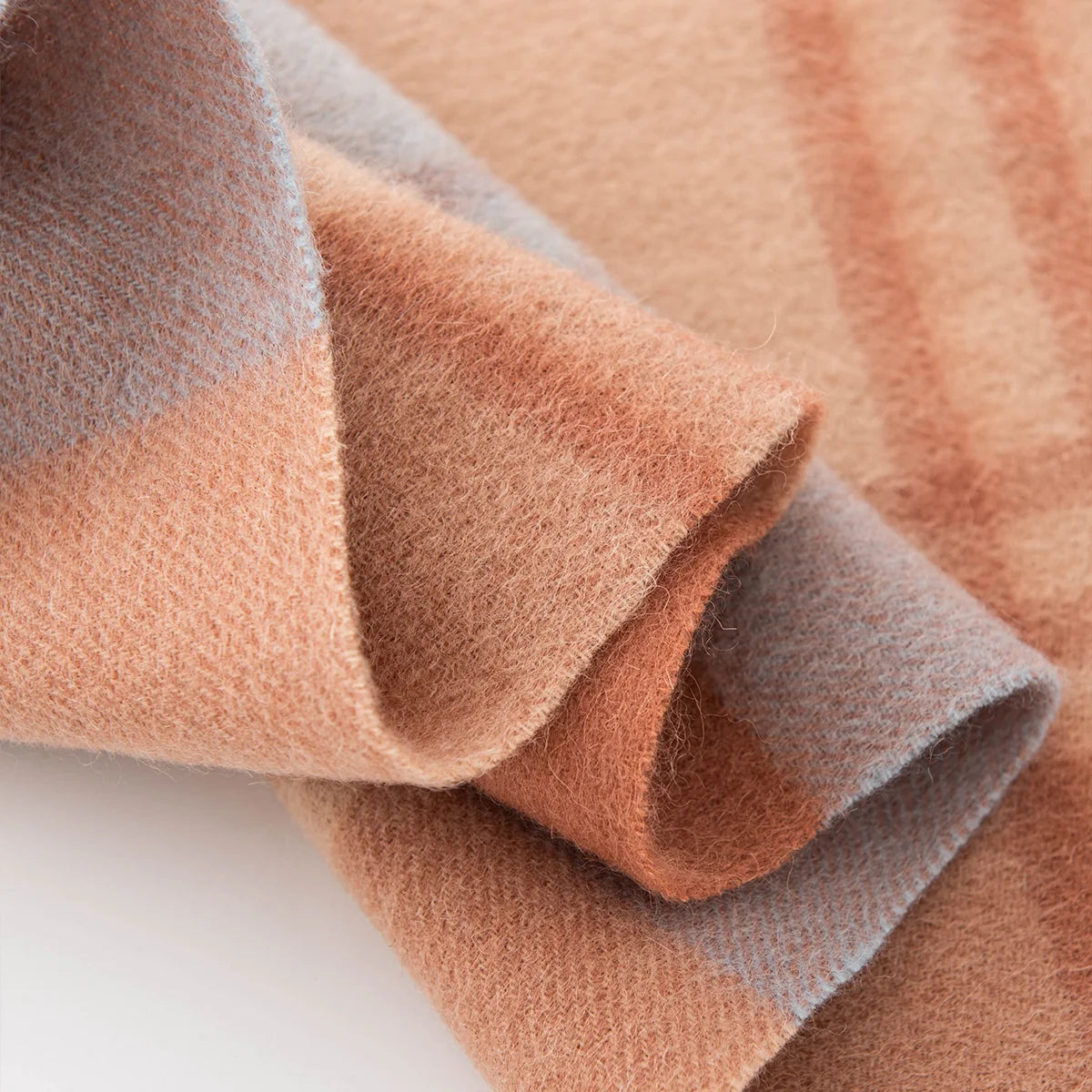 Curled peach blue fabric revealing contrasting checked sections