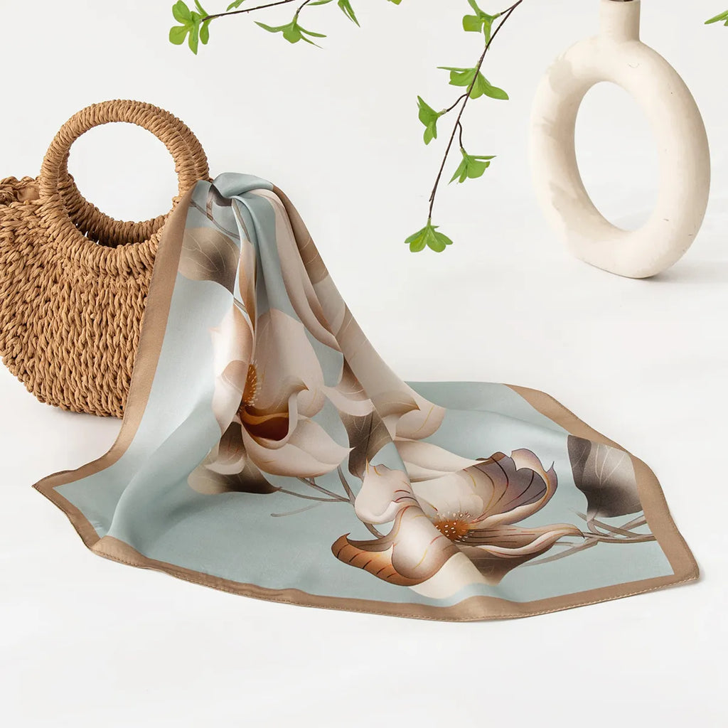 Draped blue silk scarf with large floral motif near woven bag