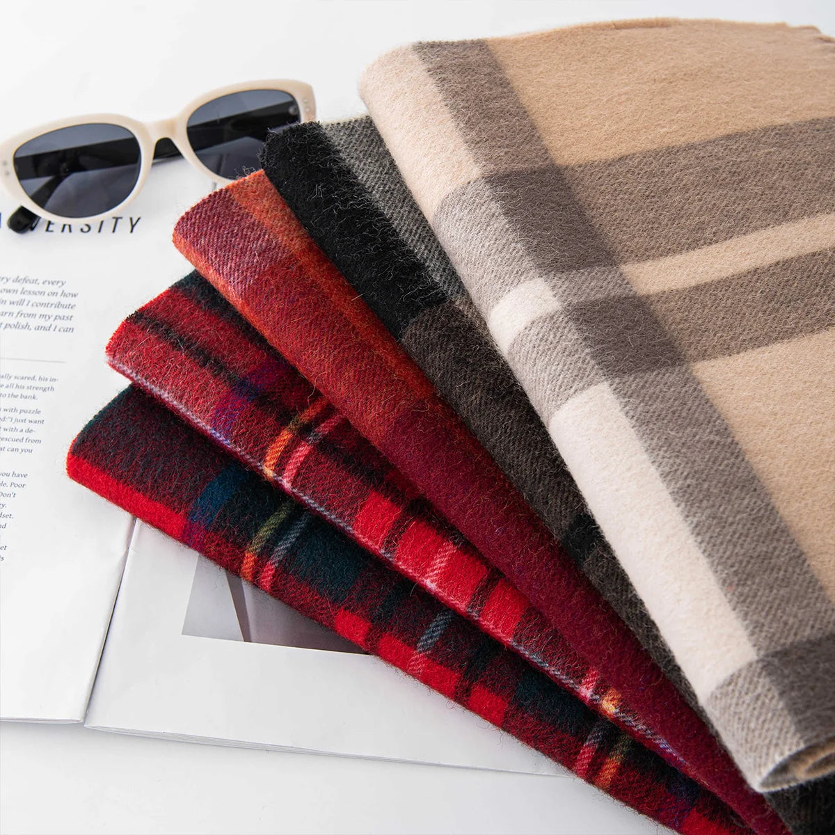 Fanned tartan wool scarves showing neutral red and dark patterns
