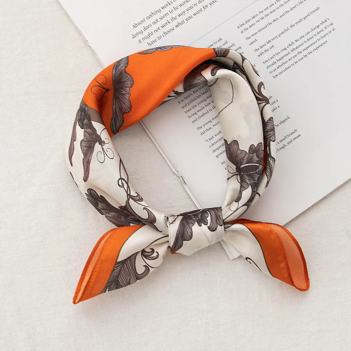 Floral silk scarf knotted on an open book
