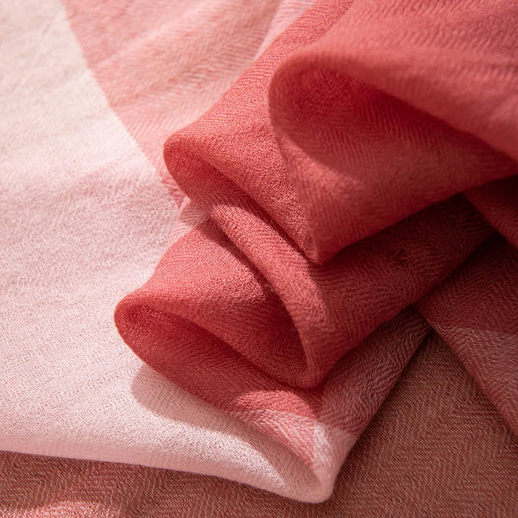 Folded rose fabric revealing lighter pink sections underneath