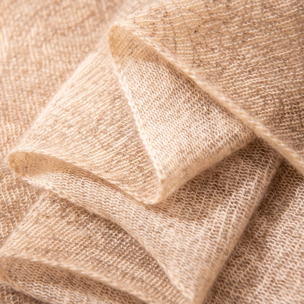 Folded camel cashmere scarf corner showing fine open woven structure
