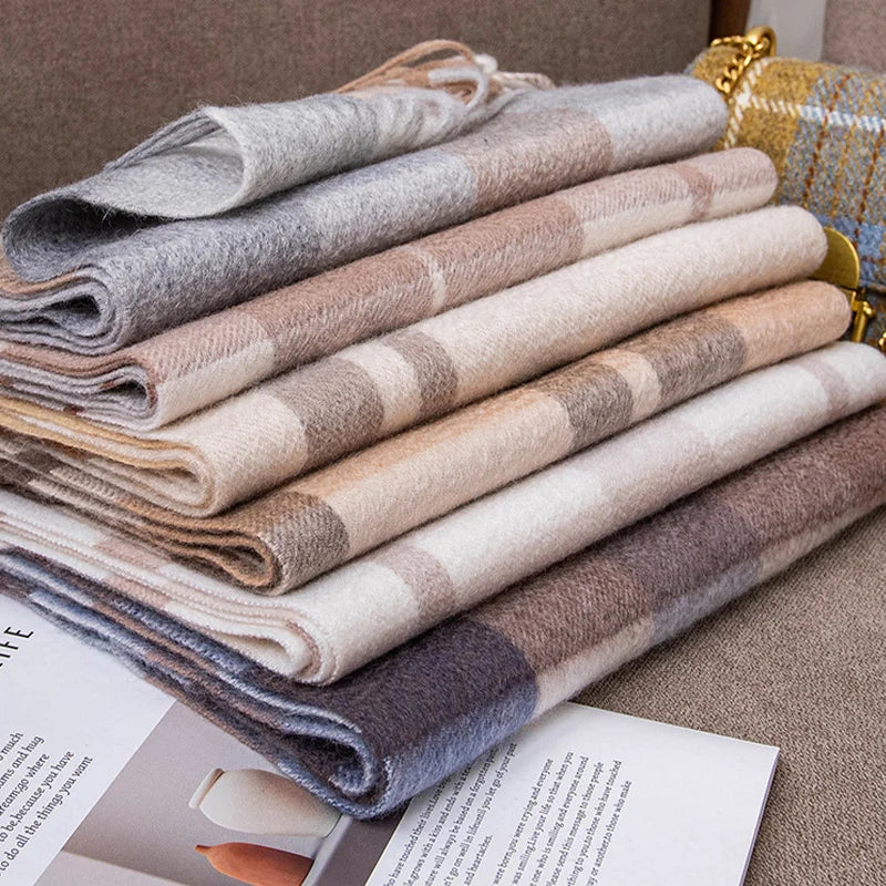 Folded checked cashmere scarves stacked in muted pastel shades