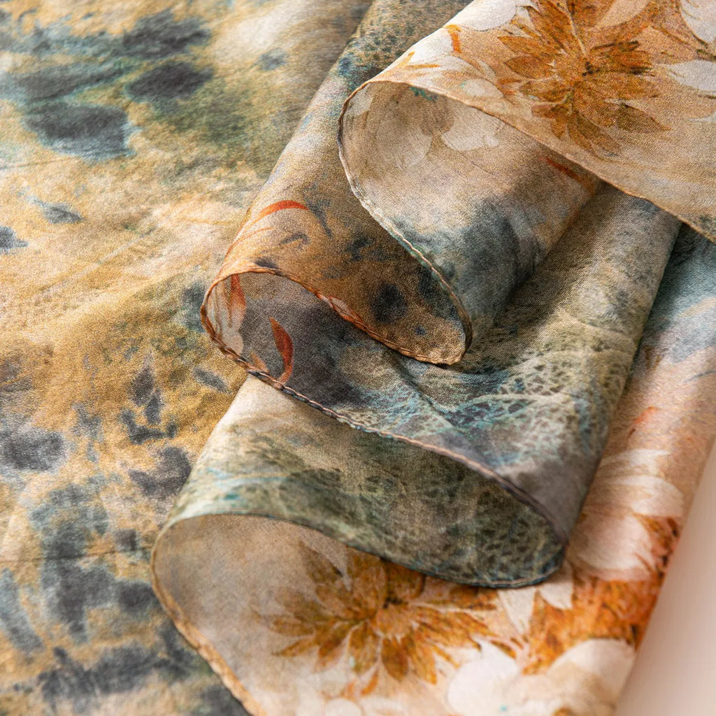 Folded emerald and ochre silk scarf close-up