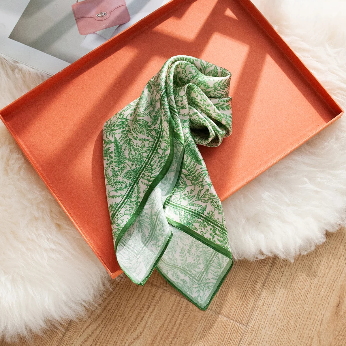 Folded green botanical Silk Square Scarf in tray