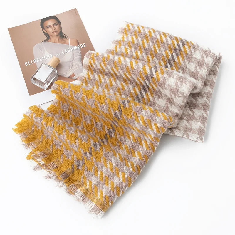 Folded mustard houndstooth scarf beside photographs on white surface