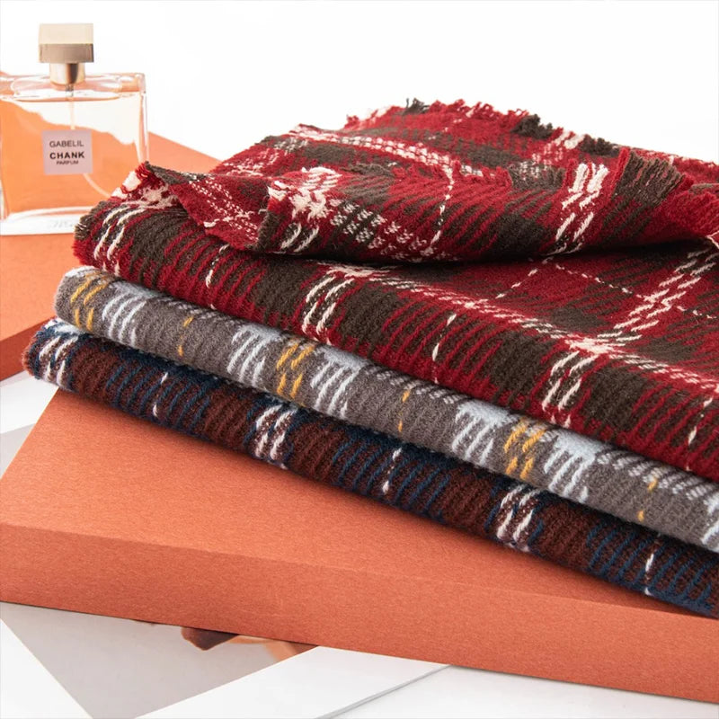 Folded tartan wool scarves stacked on an orange display box