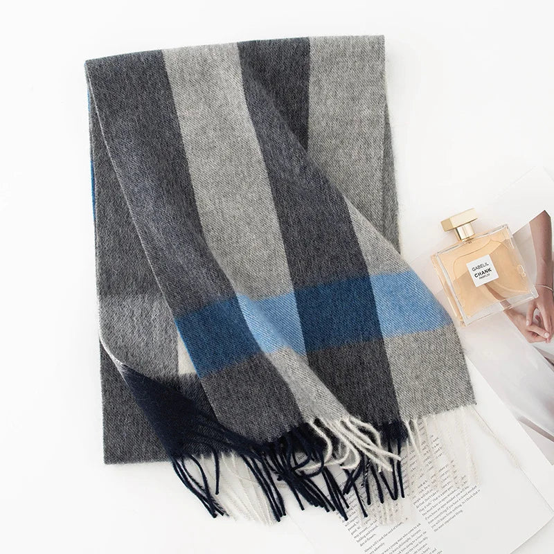 Gray striped wool scarf with blue crossband beside perfume bottle