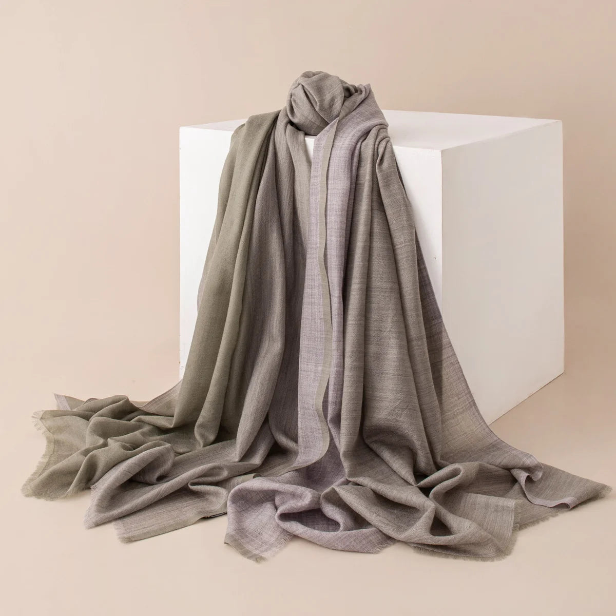 Gray tonal wool scarf draped around a white display block