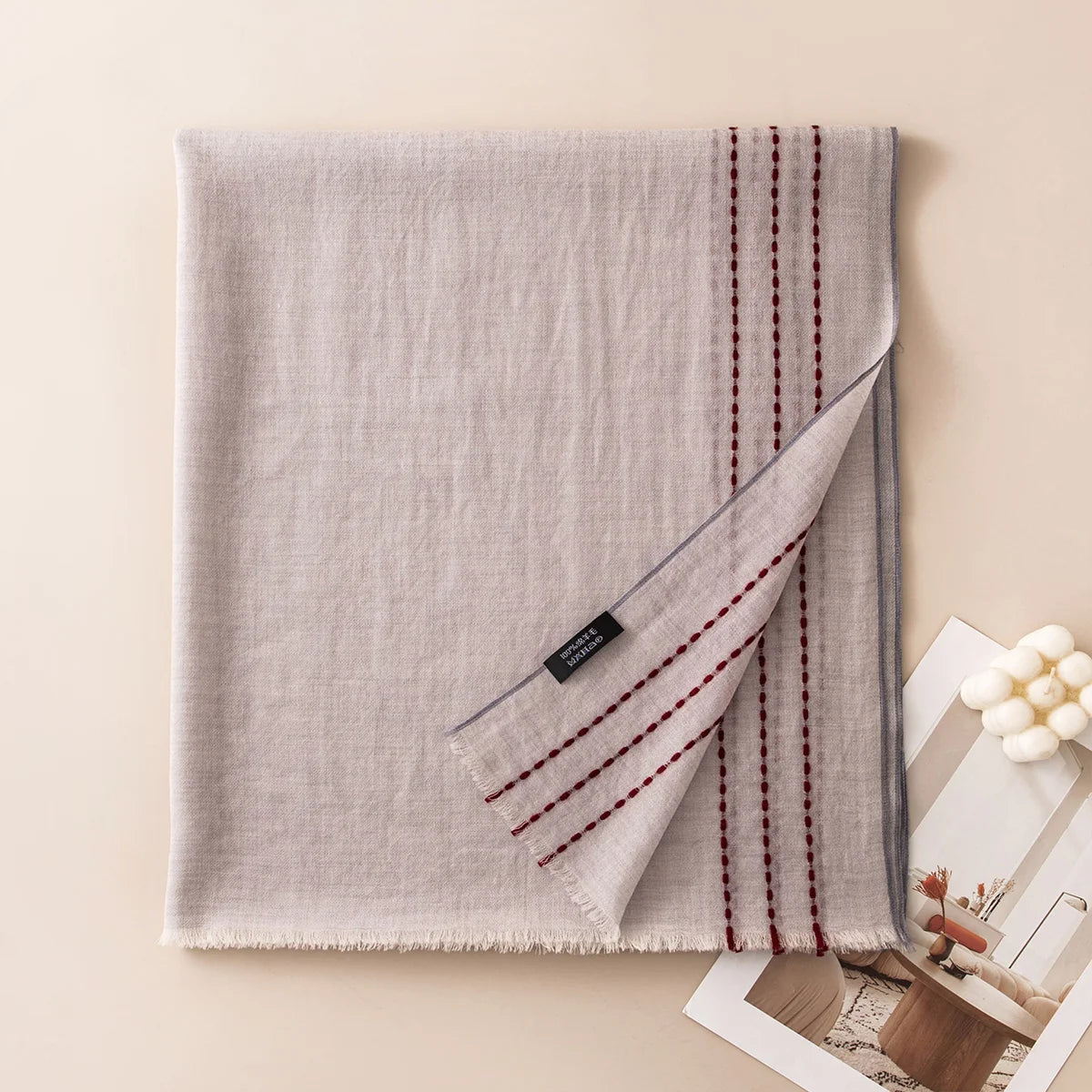 Gray wool scarf featuring burgundy running stitches along the border