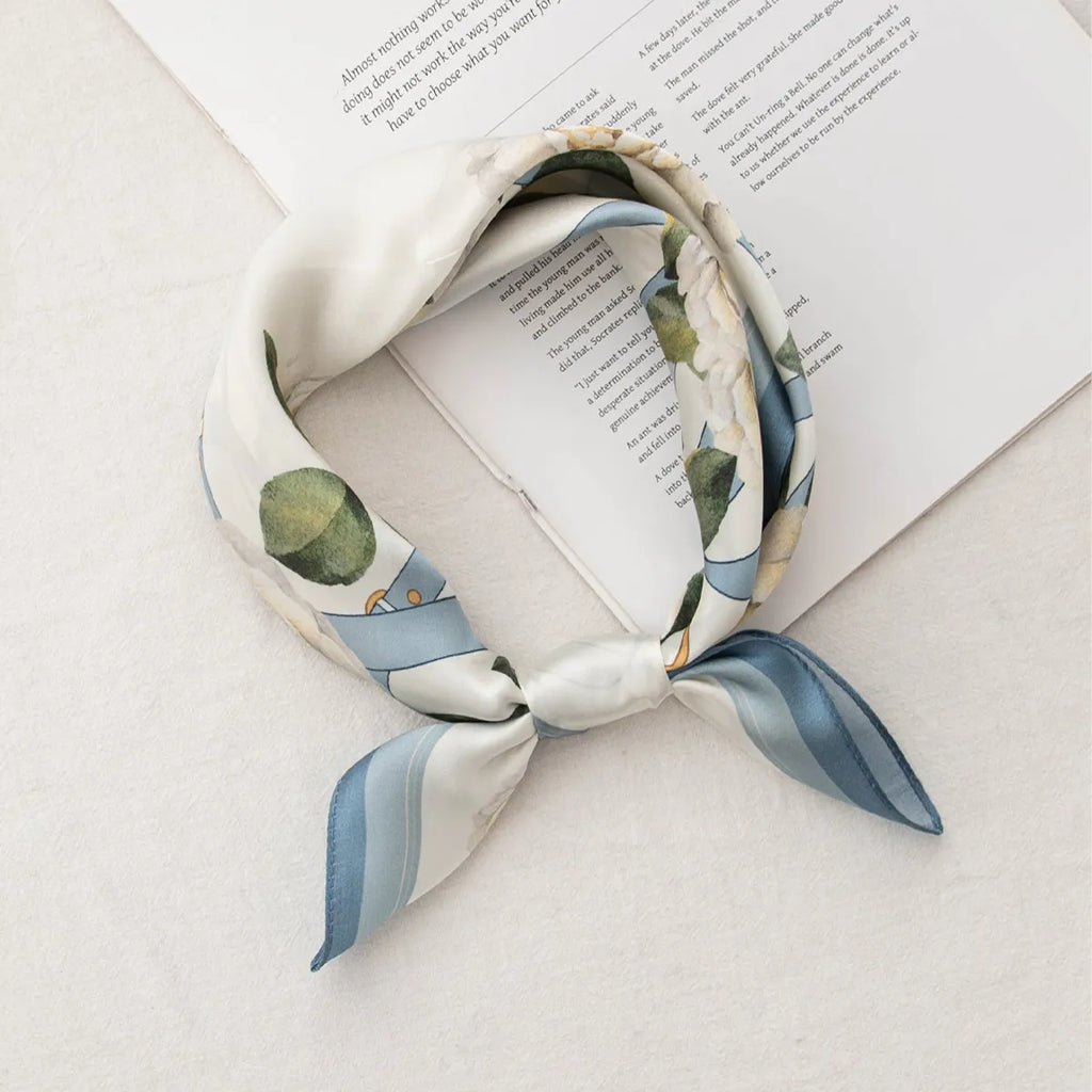 Knotted white silk scarf with blue strap and floral elements