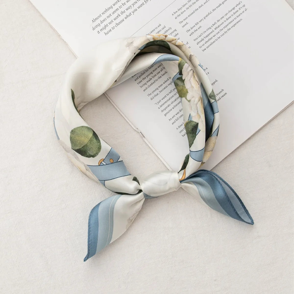 Knotted white silk scarf with blue strap and floral elements
