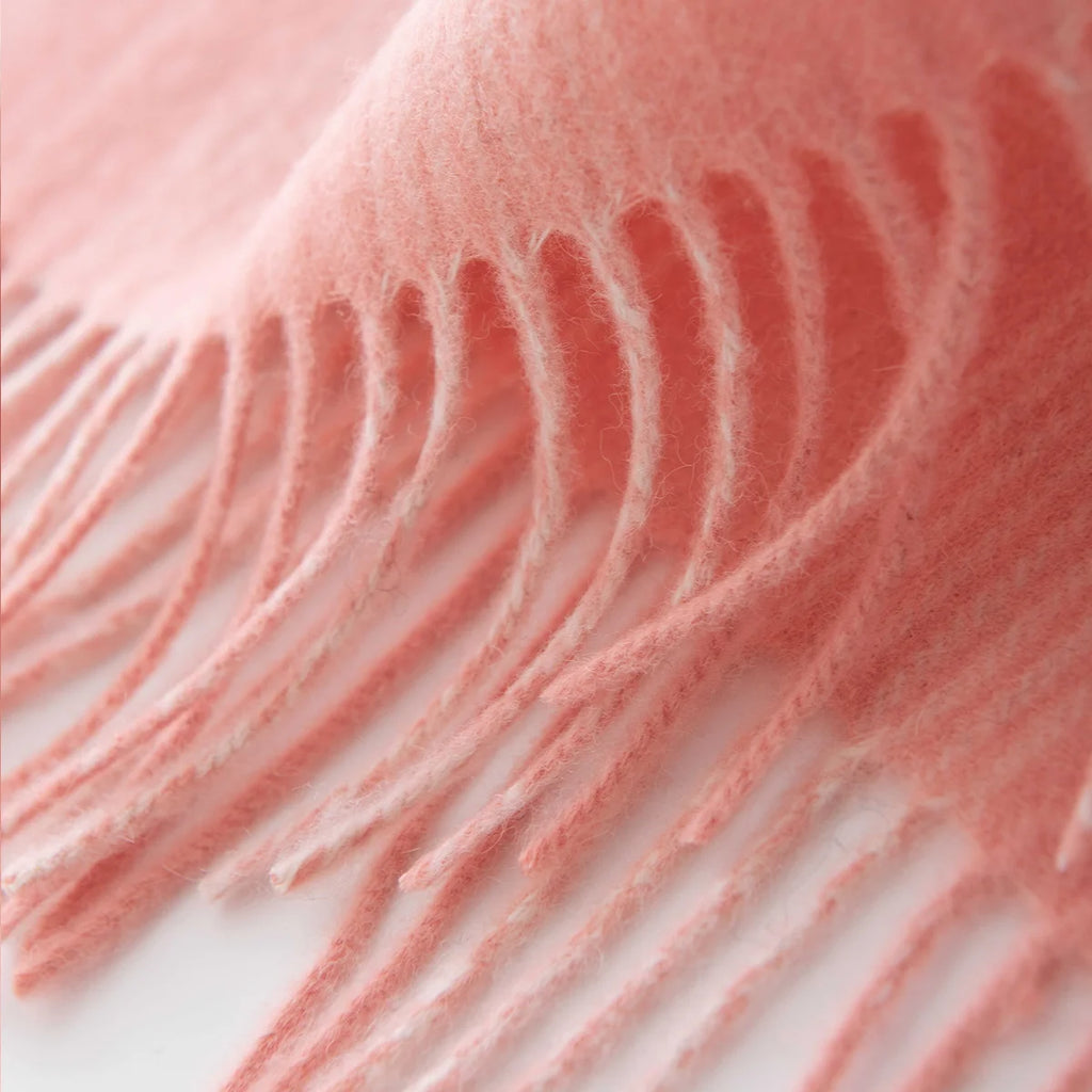 Long pale pink fringe beneath fine checked wool scarf edge