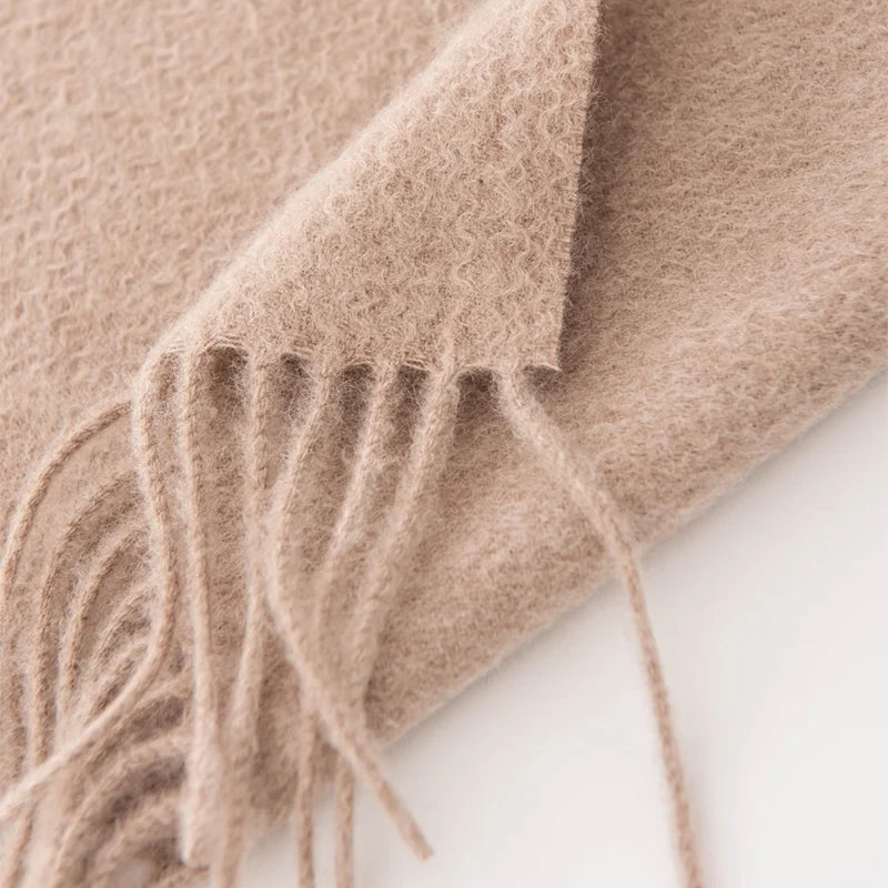 Long taupe fringe extending from the textured scarf edge