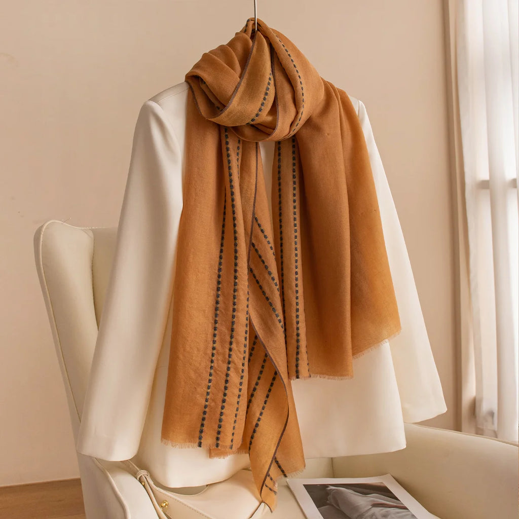 Mustard stitched border wool scarf displayed over a cream jacket