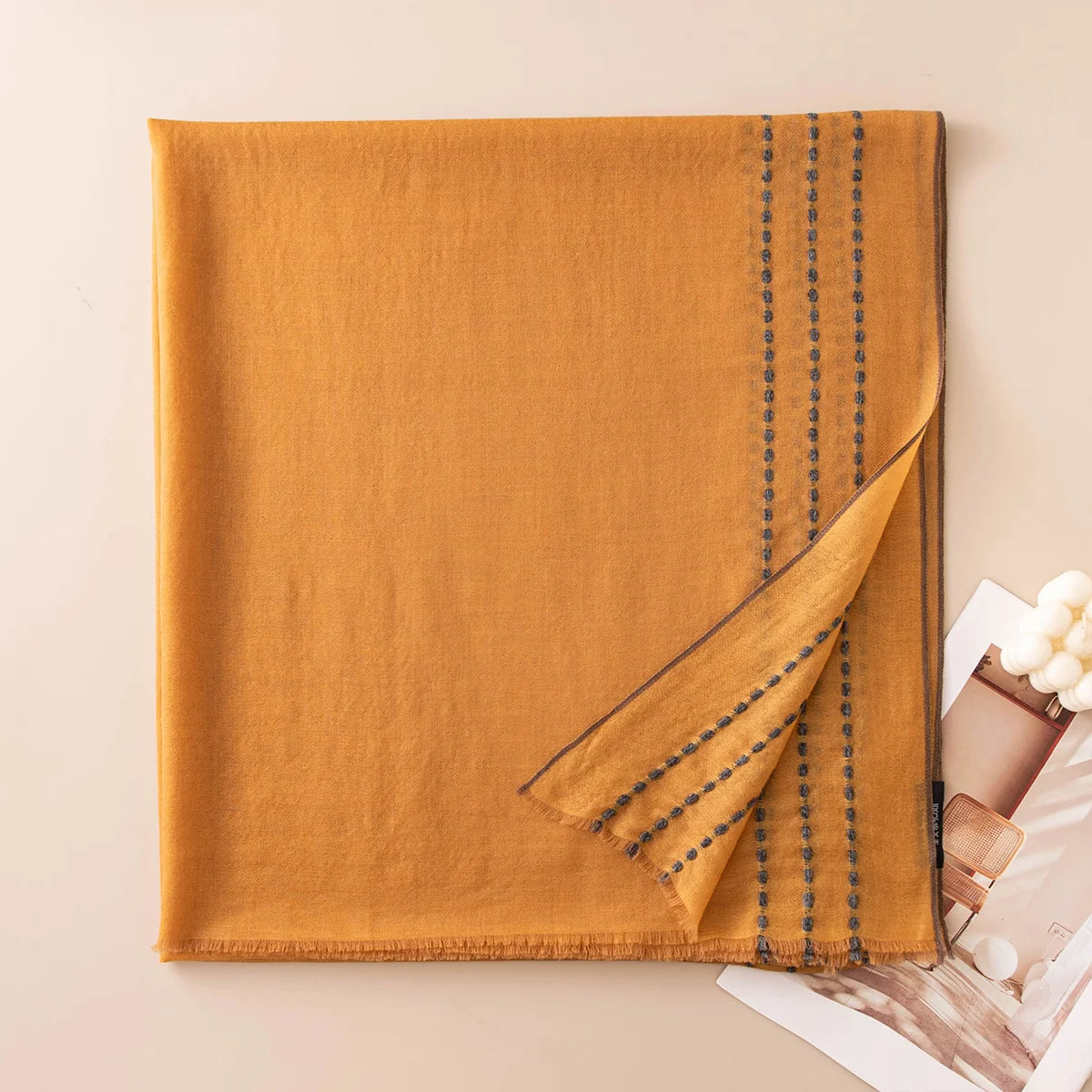 Mustard wool scarf folded to reveal rows of contrasting stitches