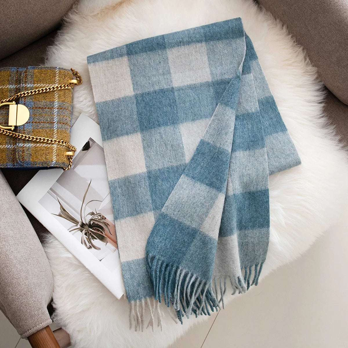 Muted blue cream checked wool scarf folded on white throw