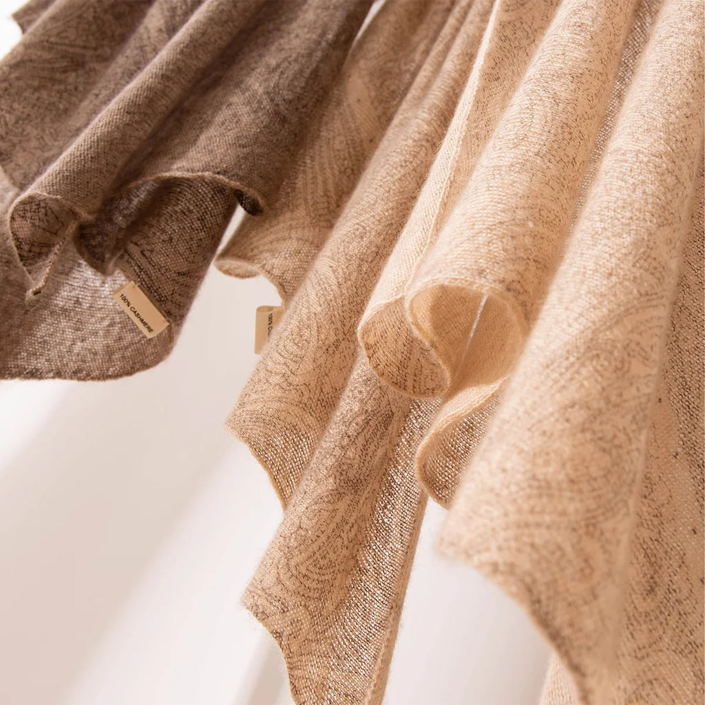 Neutral open weave cashmere scarves cascading in loose overlapping folds