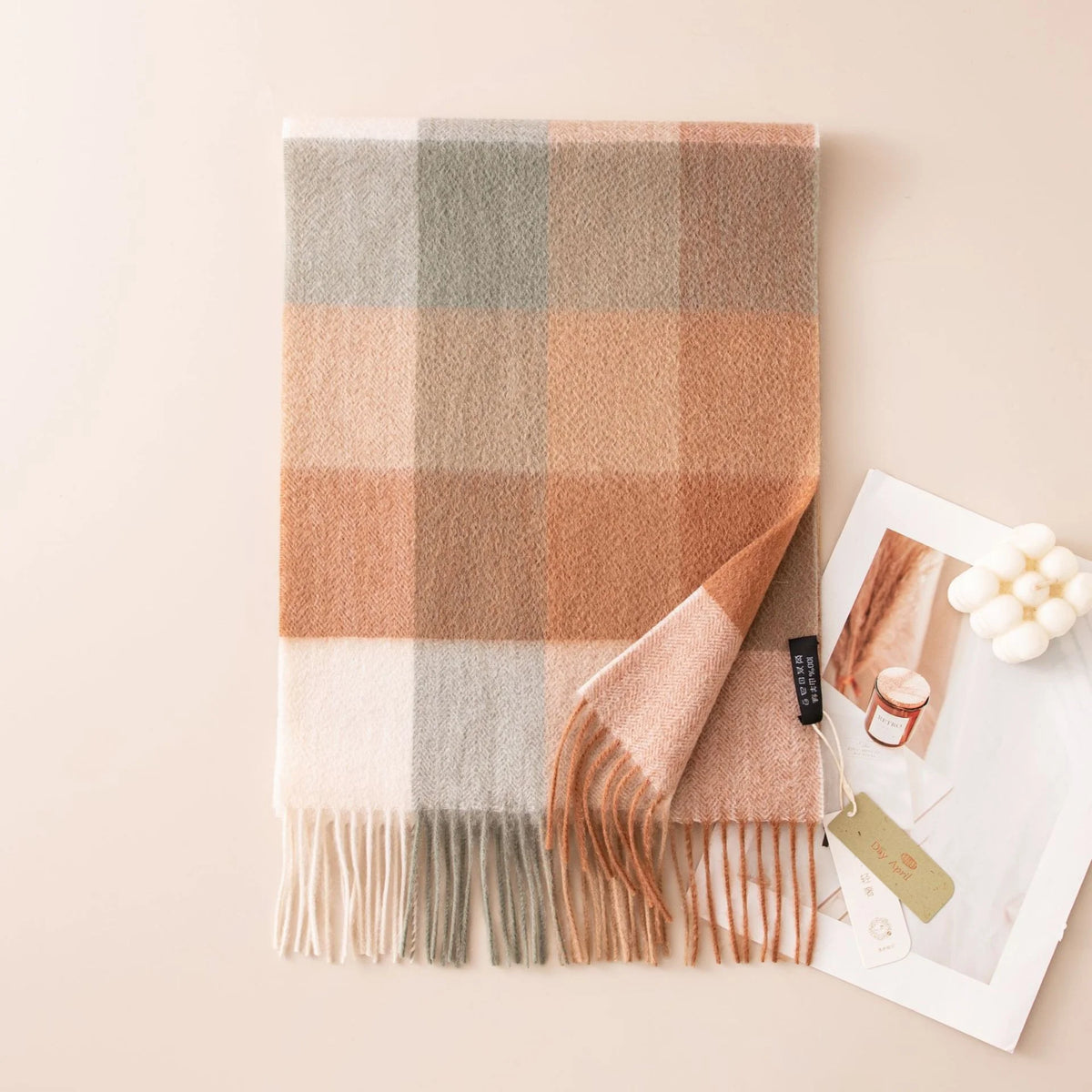 Orange gray block check cashmere scarf beside a printed portrait