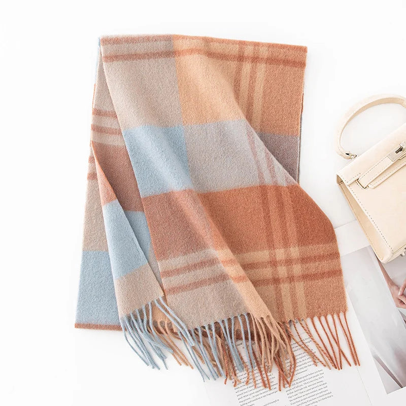Peach blue checked wool scarf folded beside a cream handbag