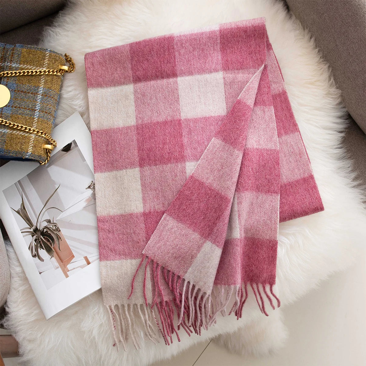 Pink cream buffalo check wool scarf displayed beside patterned handbag