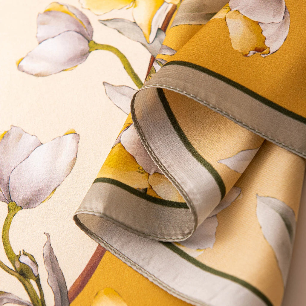 Rolled edge detail of yellow blossom silk scarf
