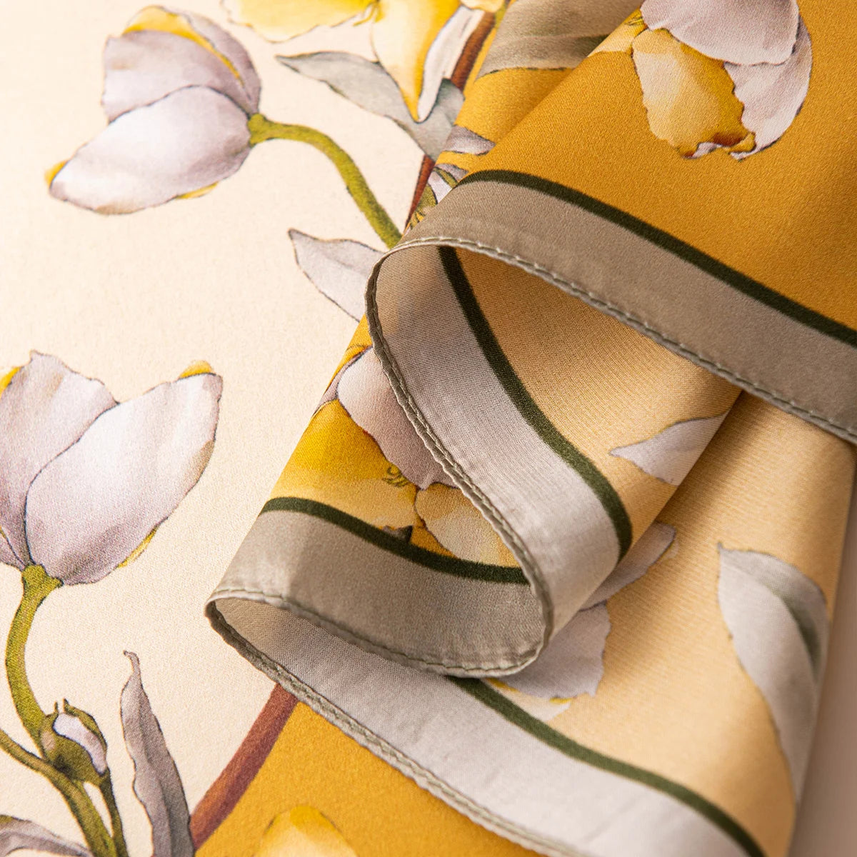 Rolled edge detail of yellow blossom silk scarf