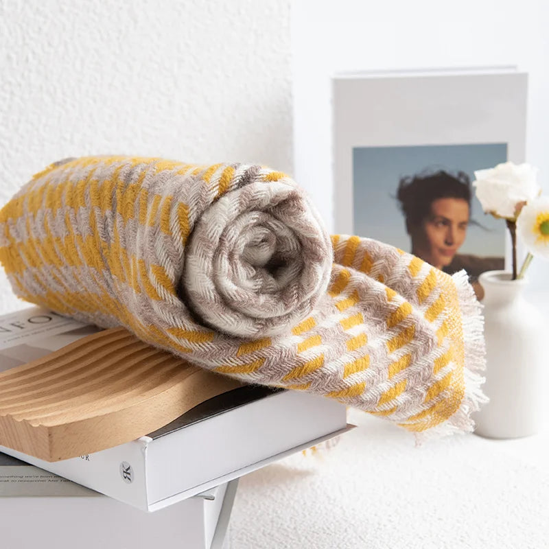 Rolled mustard houndstooth scarf resting on a wooden tray