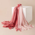 Rose pink paneled wool scarf cascading over a white block