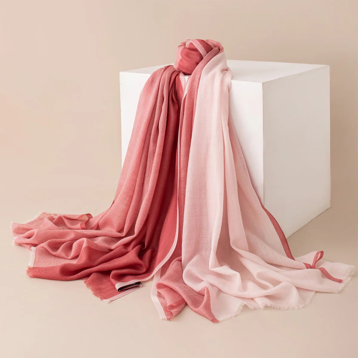 Rose pink paneled wool scarf cascading over a white block