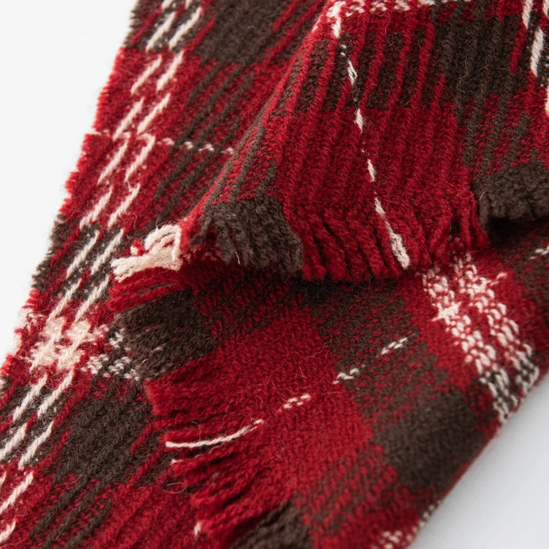 Short red and dark fringe beneath textured plaid fabric