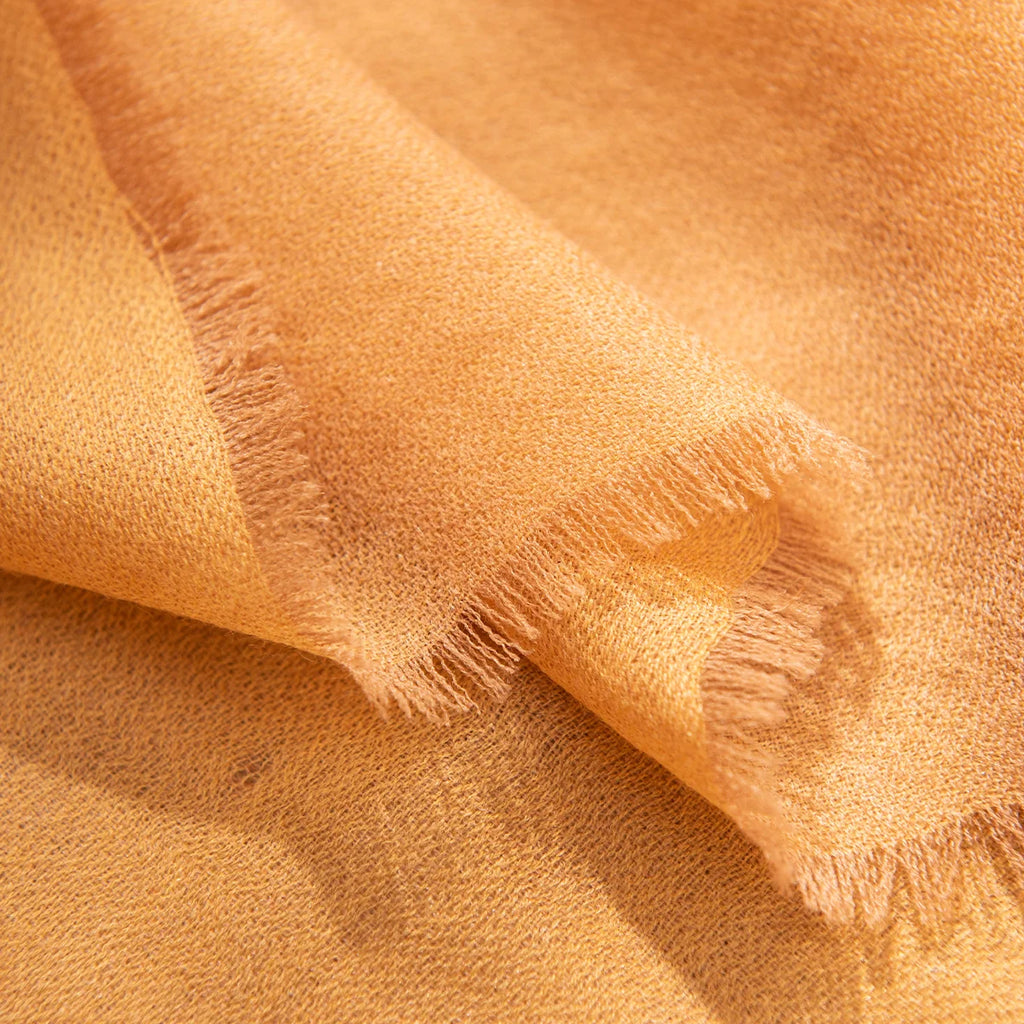 Short wispy fringe along the mustard wool scarf edge