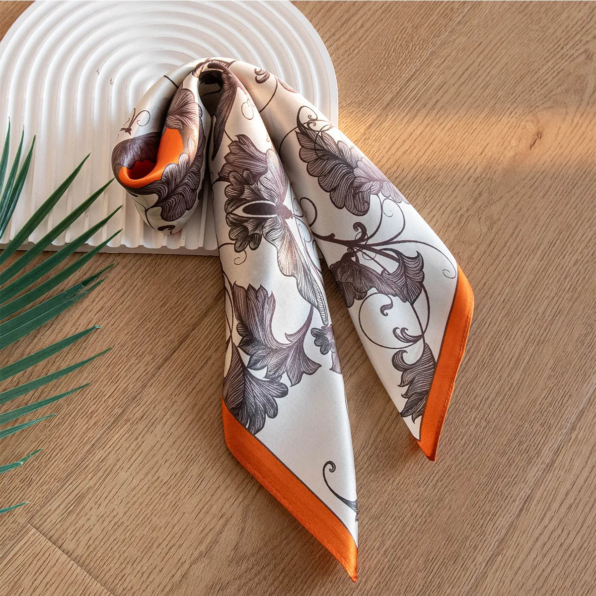 Silk scarf knotted on a white arched tray