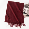 Solid burgundy fringed scarf on white background