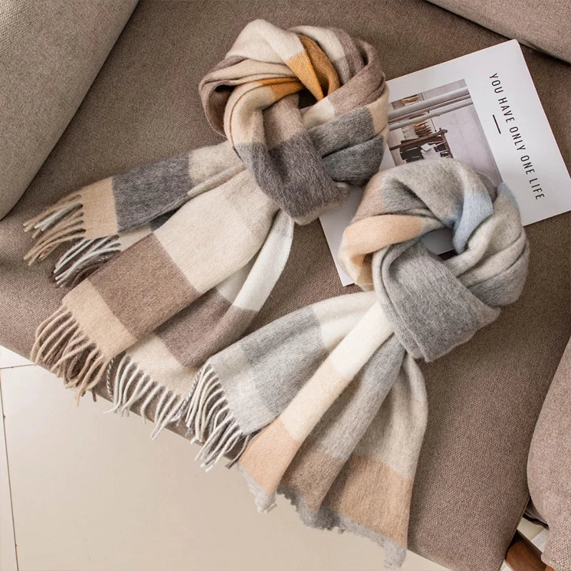 Two neutral checked wool scarves loosely knotted beside printed magazine