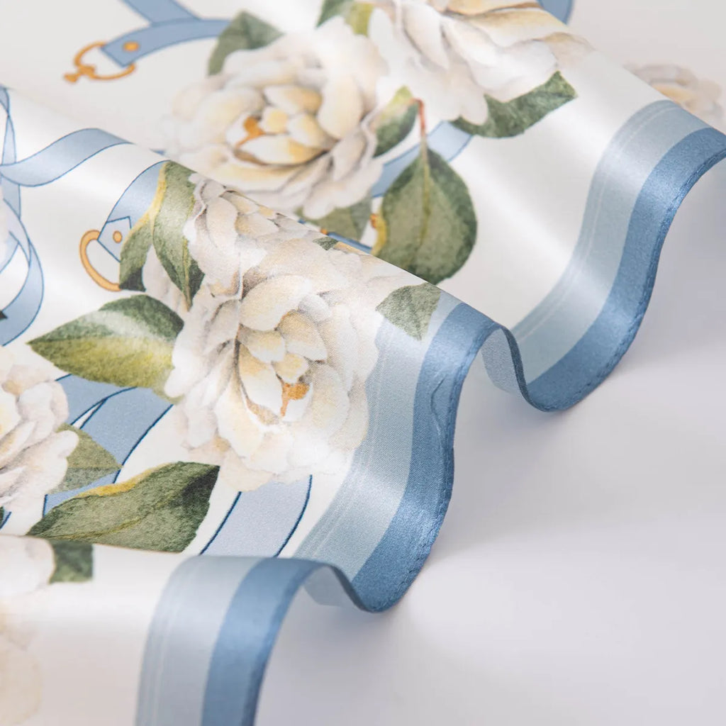 Wavy blue rolled edge on white floral silk scarf