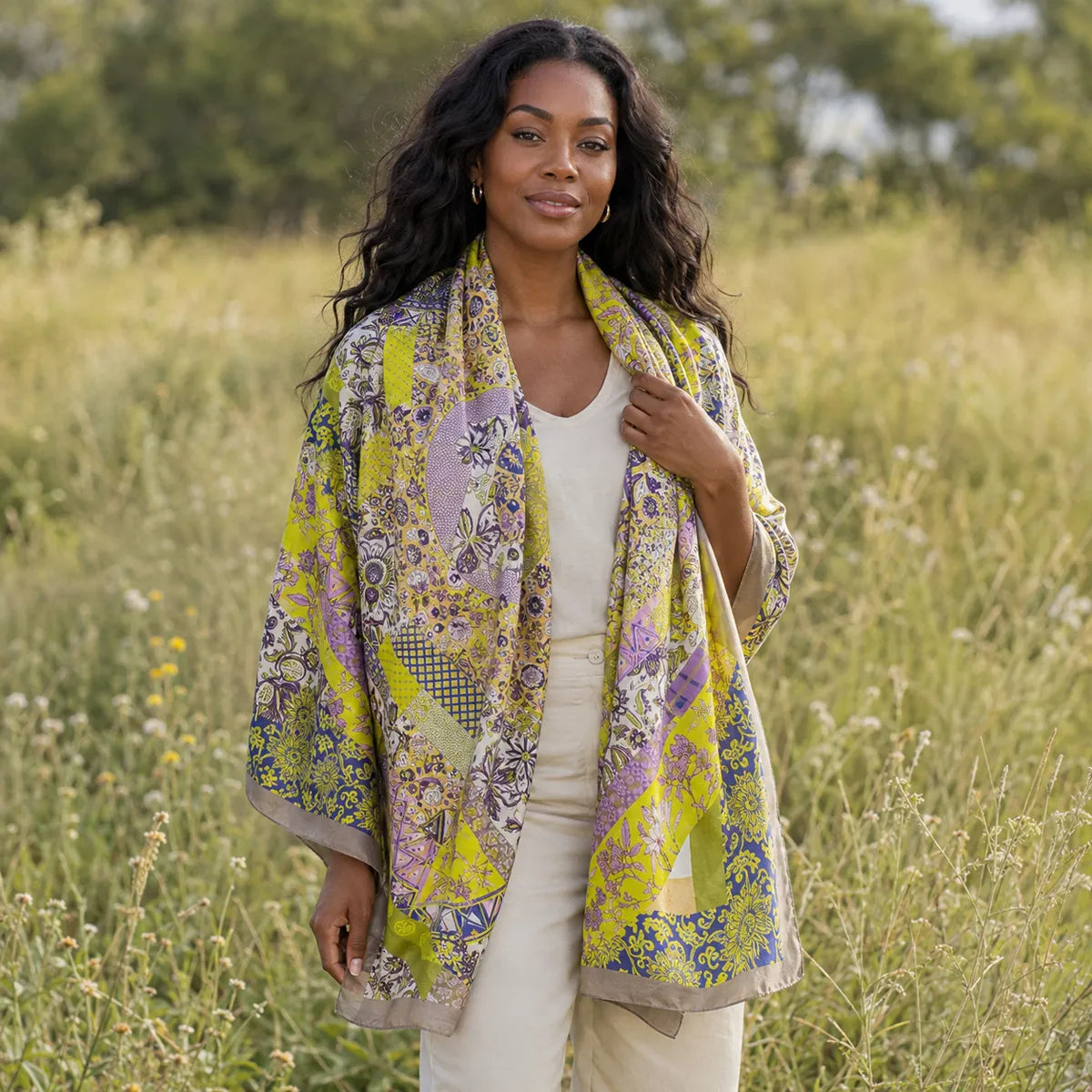 Woman styling citron paisley silk scarf in meadow