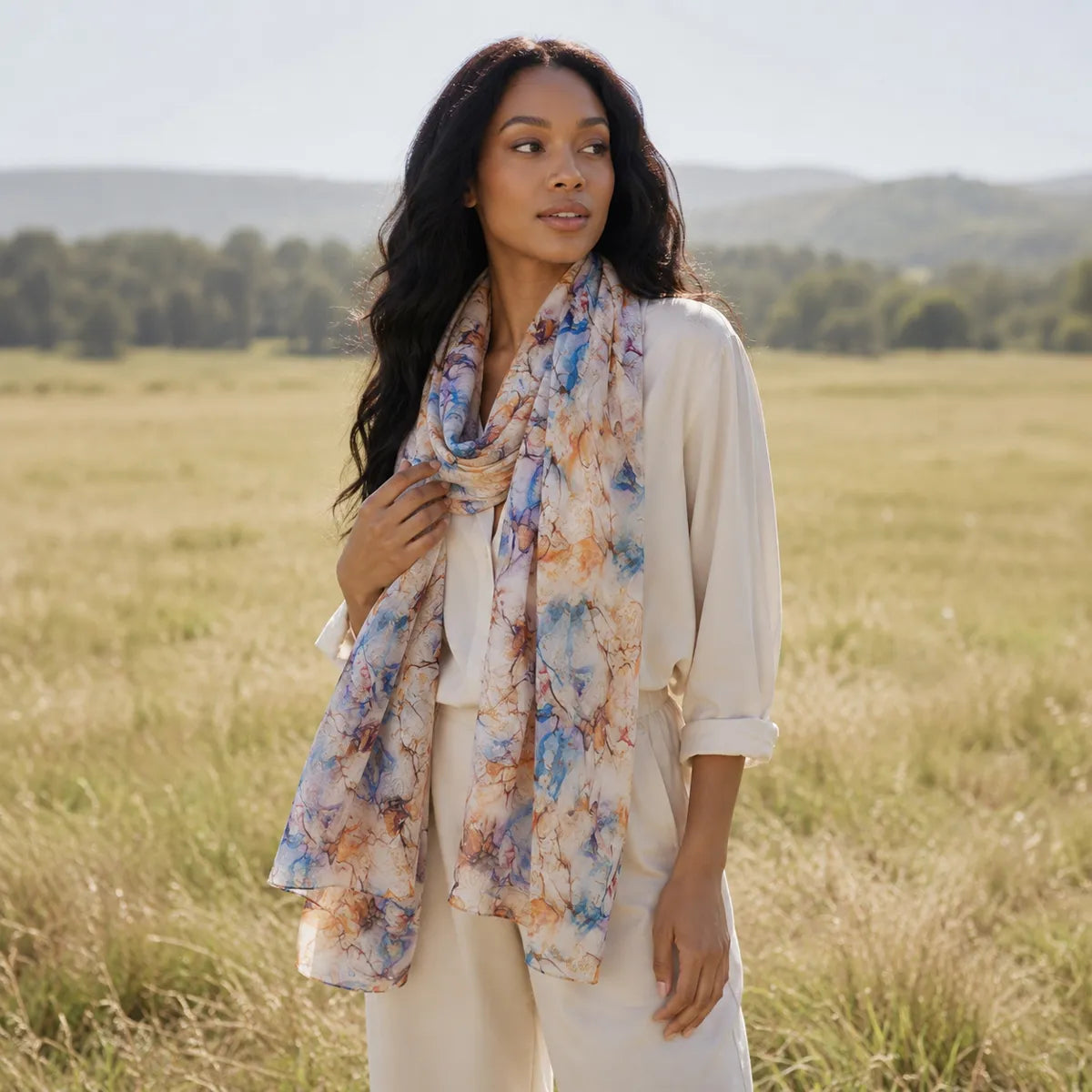 Woman styling watercolor silk scarf in meadow
