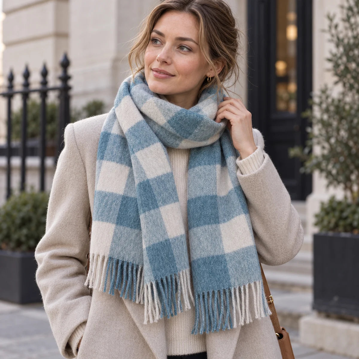 Woman wearing blue buffalo check wool scarf with light coat
